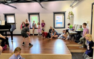 Elementary students participating in a hands-on music activity during summer music camp at Lott Music Studio in Ames, IA.