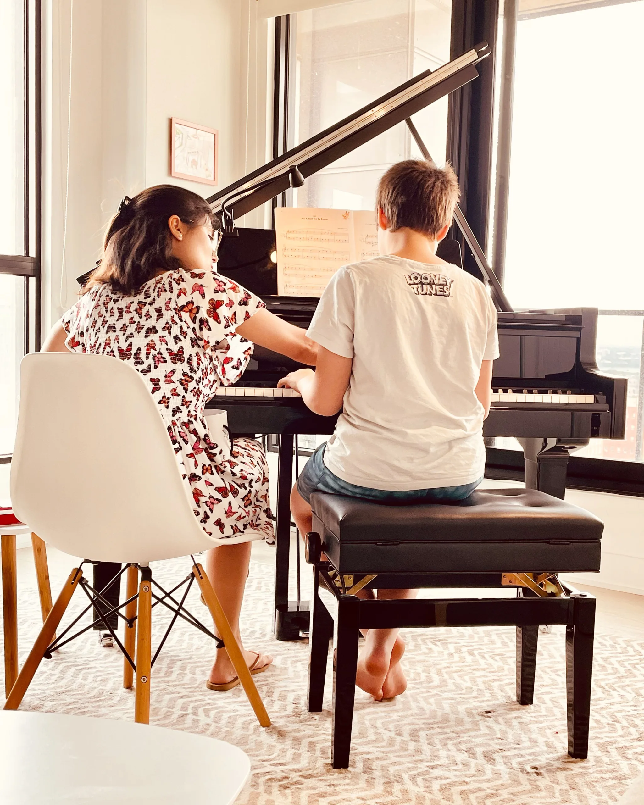 A piano instructor giving a one-on-one music lesson during the back-to-school season at Lott Music Studio.
