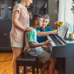 Parents helping a middle school student with his piano practice during Parents Week at Lott Music Studio.