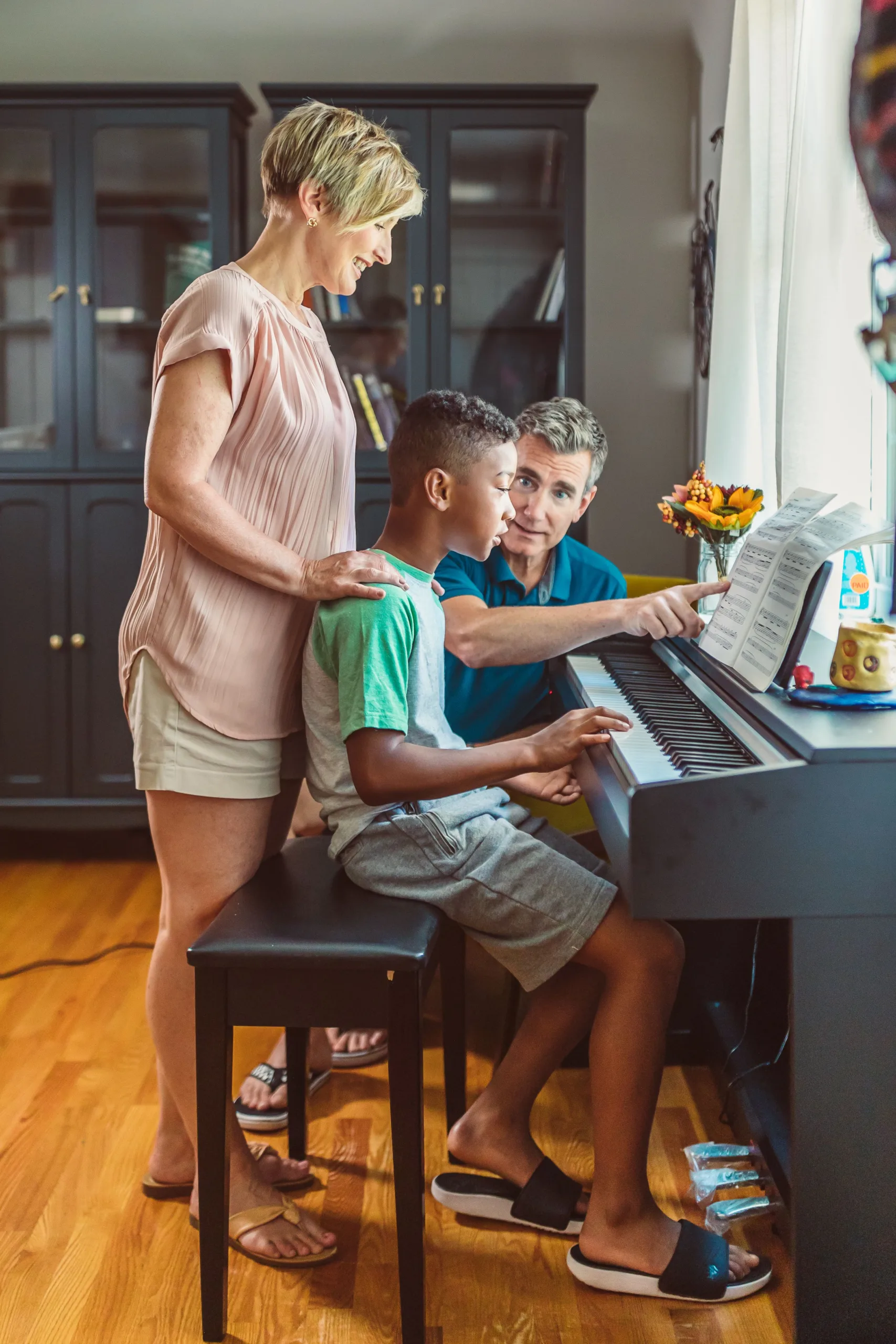 Parents helping a middle school student with his piano practice during Parents Week at Lott Music Studio.